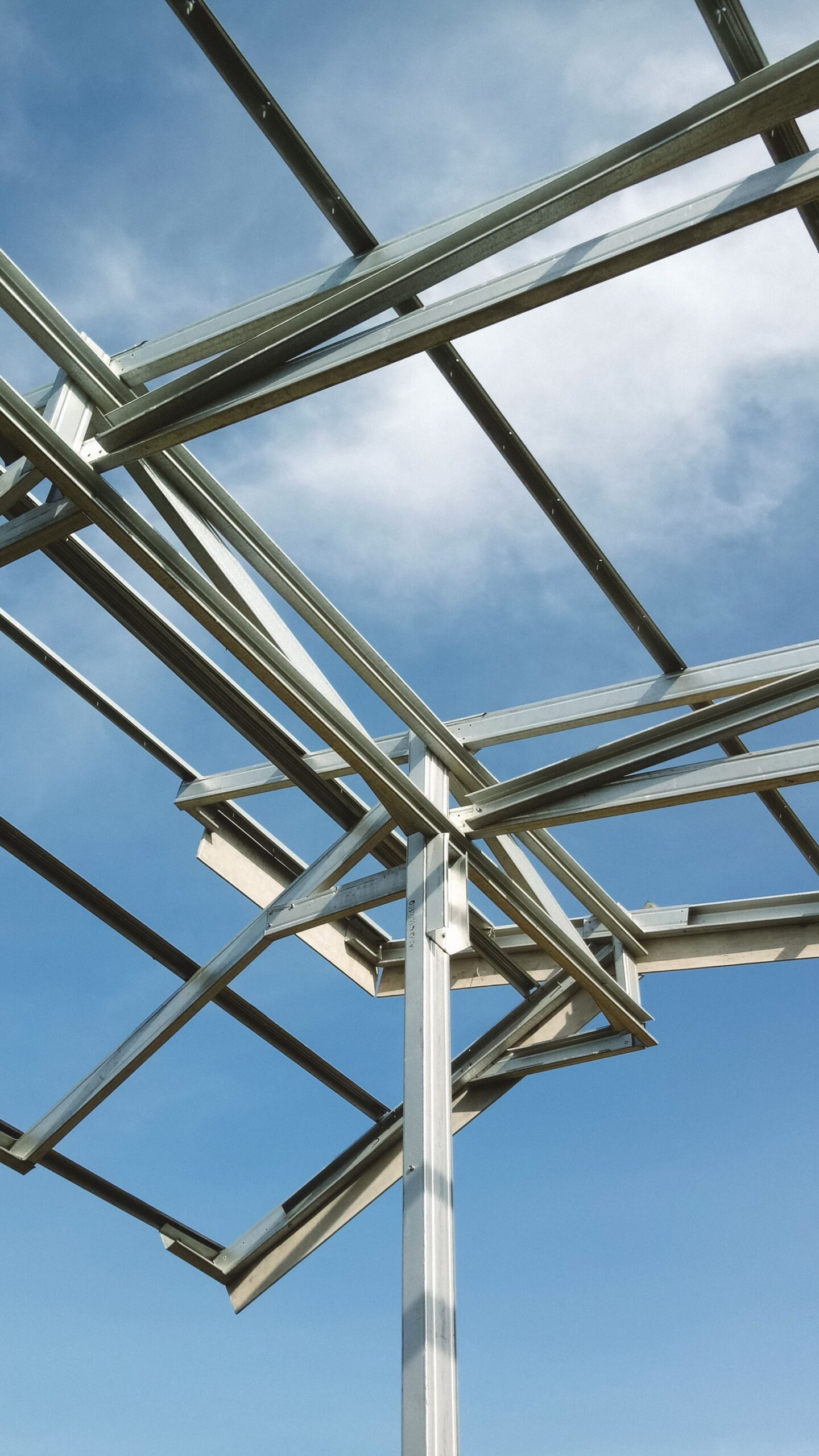 Light steel frame roof truss under a clear blue sky.